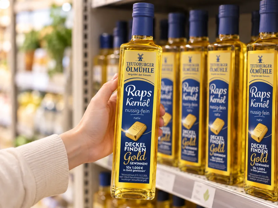 Eine Hand nimmt eine Aktionsflasche Rapskernöl nussig-fein aus dem Supermarktregal