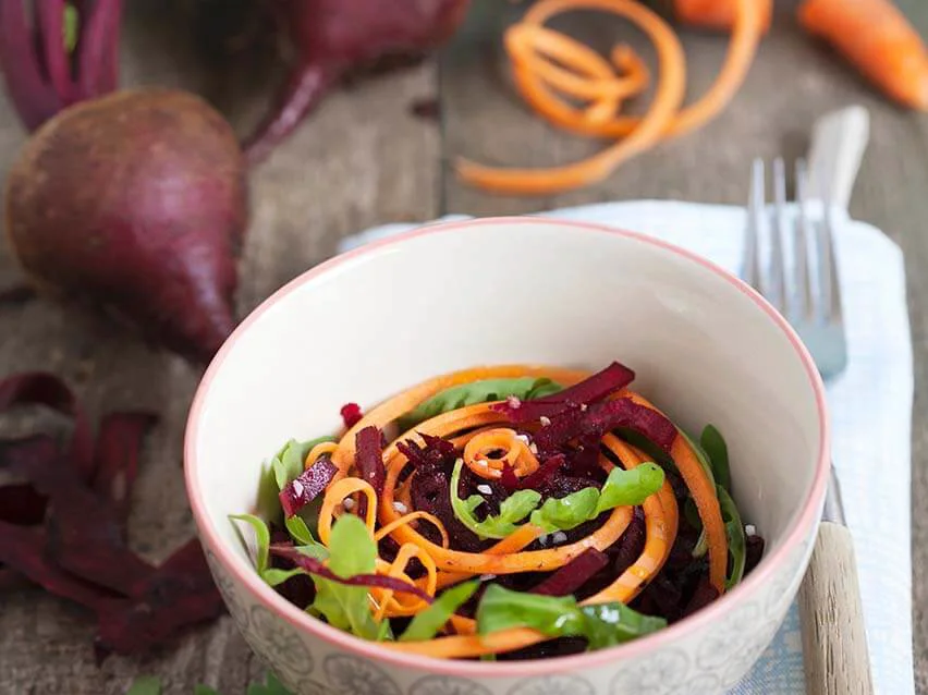 Rote-Beete-Salat mit Karottenstreifen und Rucola in einer Schale