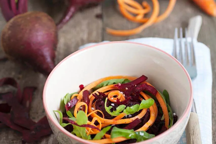 Rote-Beete-Salat mit Karottenstreifen und Rucola in einer Schale