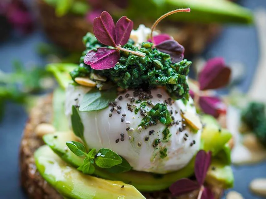 Vollkornbrot mit Avocado, pochiertem Ei und grünem Pesto