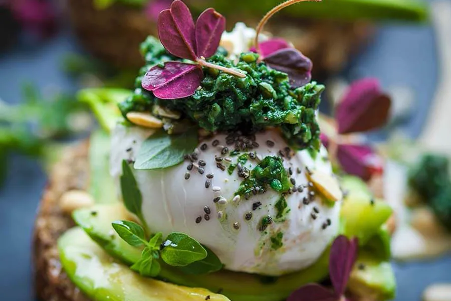 Vollkornbrot mit Avocado, pochiertem Ei und grünem Pesto