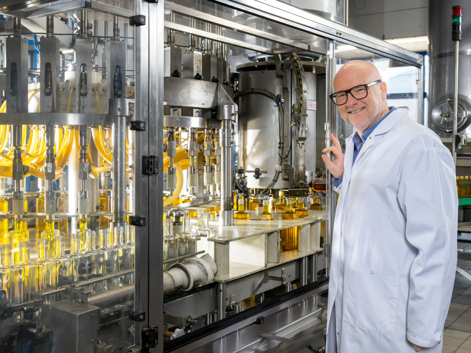 Mann steht an Abfuellmaschine